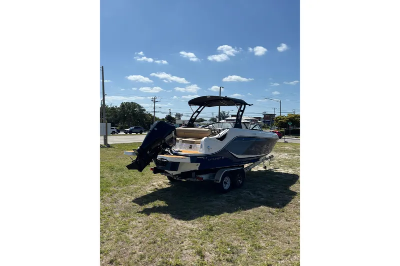 Slide: The Image of 2026 Bayliner D22 boat on trailer under clear blue sky. - 2