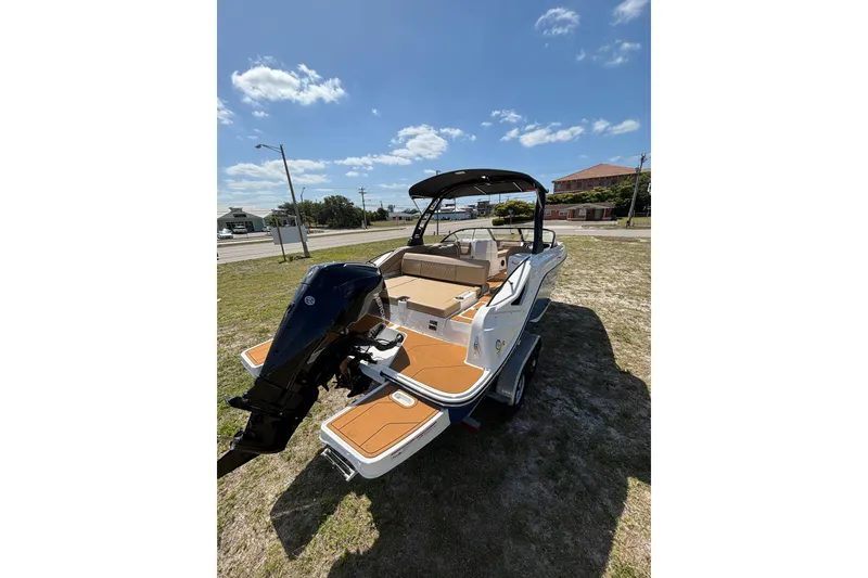 Slide: The Image of 2026 Bayliner D22 boat with outboard motor on grassy area under blue sky. - 21