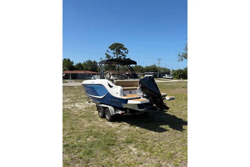 Slide: The Image of 2026 Bayliner D22 boat on trailer, parked on grass under clear blue sky. - 4