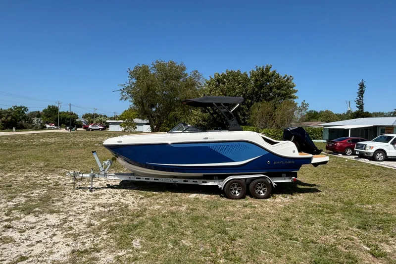 Slide: The Image of 2026 Bayliner D22 boat on trailer, parked on grass under clear blue sky. - 6