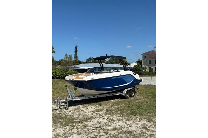 Slide: The Image of 2026 Bayliner D22 boat on trailer, parked outdoors under clear blue sky. - 7