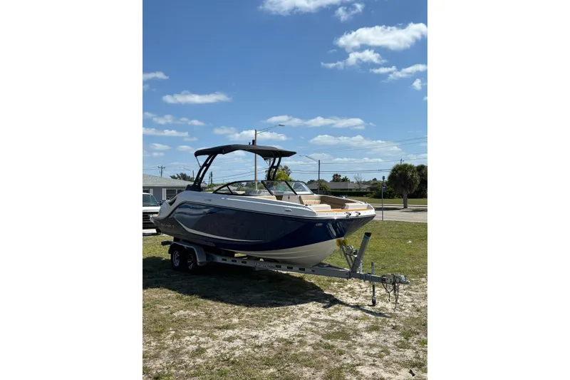 Slide: The Image of 2026 Bayliner D22 boat on trailer under clear blue sky. - 9