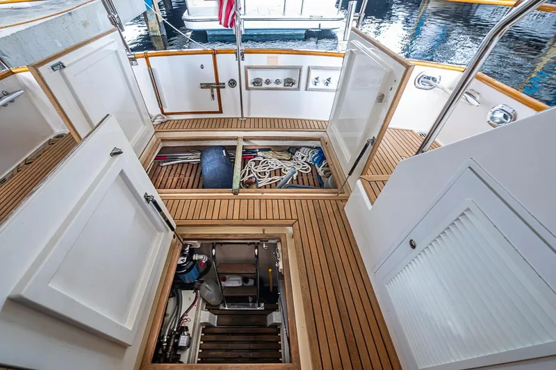Slide: The Image of 2002 Grand Banks 42 Europa yacht deck with open storage compartments and nautical equipment. - 13