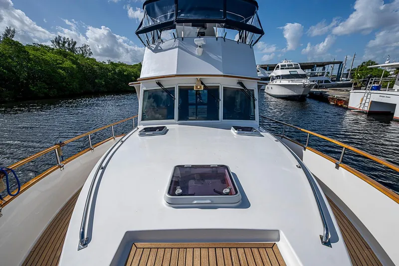 Slide: The Image of 2002 Grand Banks 42 Europa yacht on calm water, showcasing sleek deck design. - 19