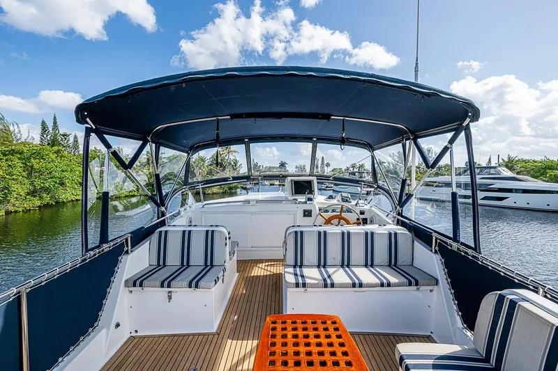 Slide: The Image of 2002 Grand Banks 42 Europa yacht with striped seating, docked on a sunny day. - 21