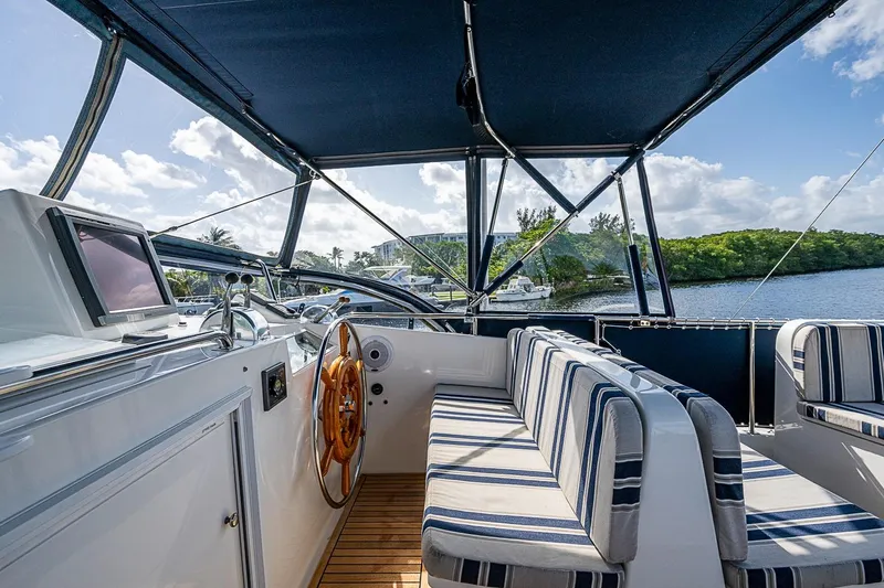 Slide: The Image of Helm of 2002 Grand Banks 42 Europa yacht with striped seating and wooden wheel. - 22