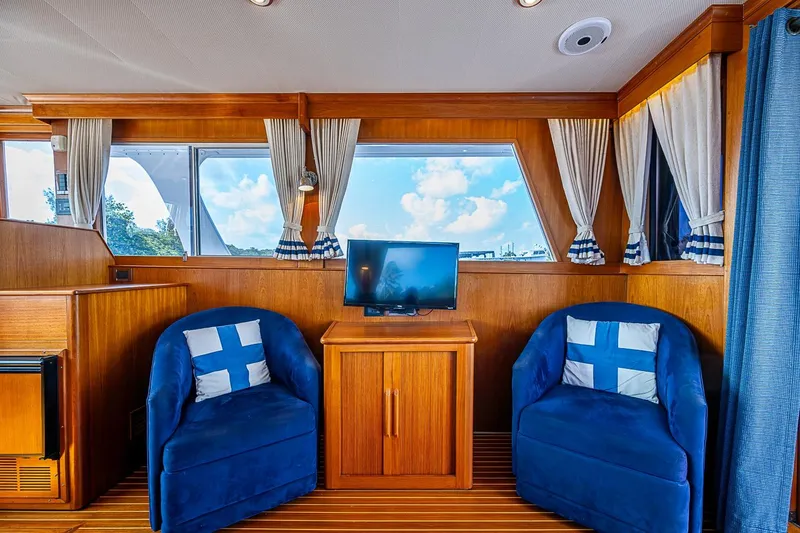 Slide: The Image of Interior of 2002 Grand Banks 42 Europa with blue chairs and a small TV. - 31