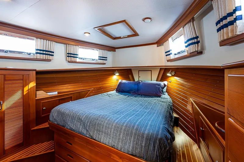 Slide: The Image of Luxurious cabin interior of 2002 Grand Banks 42 Europa yacht with wood paneling and cozy bed. - 42