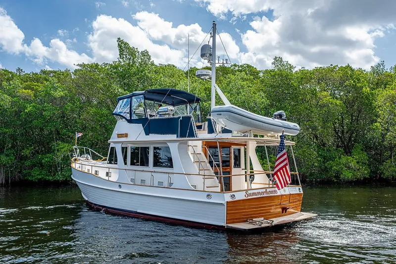 Slide: The Image of 2002 Grand Banks 42 Europa yacht cruising on a scenic waterway with lush greenery. - 8