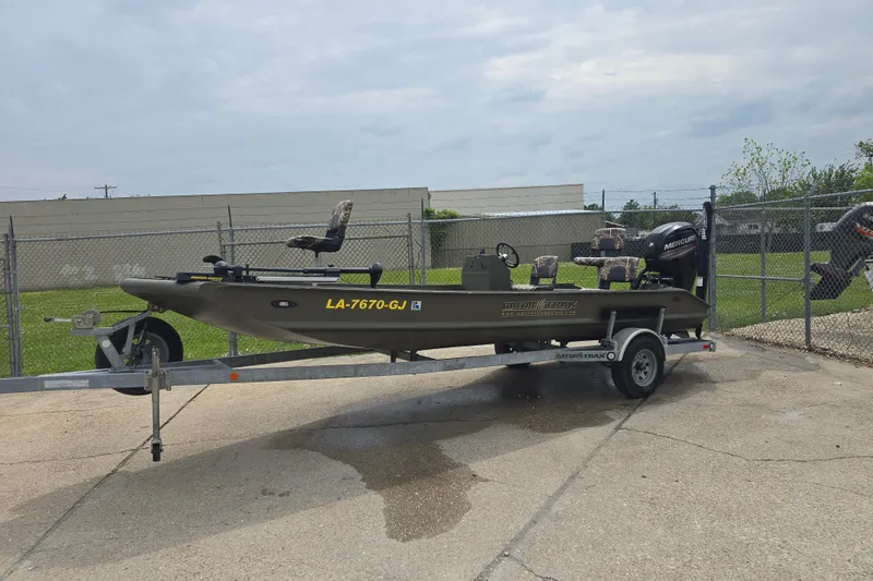 The Image of 2019 Gator Trax 18X54 boat on trailer, parked outdoors near a chain-link fence. - 0