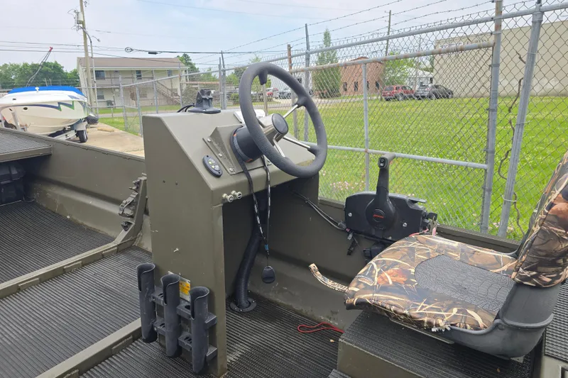 Slide: The Image of 2019 Gator Trax 18X54 boat interior with steering wheel and camo seat. - 2