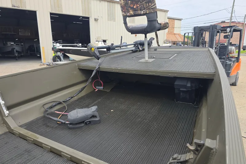 Slide: The Image of 2019 Gator Trax 18X54 boat with trolling motor and camo seat, parked near warehouse. - 4