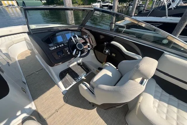 Slide: The Image of 2018 Cobalt R5 boat interior with steering wheel and seating at a marina. - 11