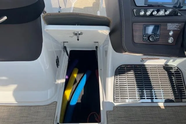 Slide: The Image of 2018 Cobalt R5 boat interior with open storage compartment containing colorful pool noodles. - 14