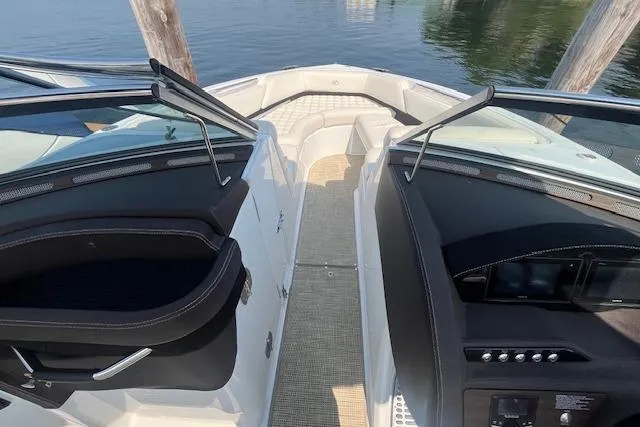 Slide: The Image of 2018 Cobalt R5 boat interior with dual consoles and seating, docked on calm water. - 18