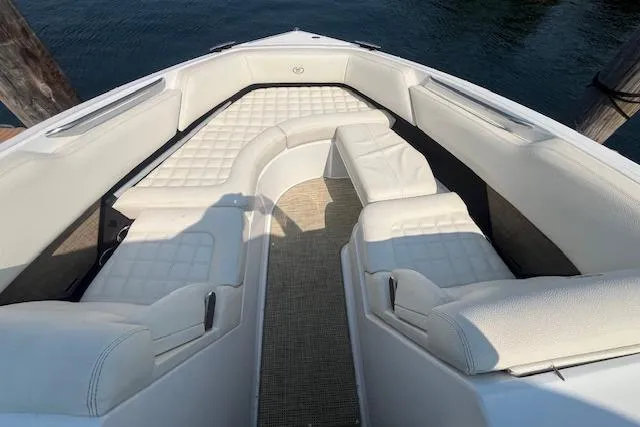 Slide: The Image of 2018 Cobalt R5 boat interior with white cushioned seating and water view. - 19