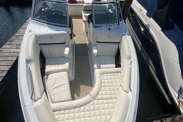 Slide: The Image of 2018 Cobalt R5 boat with white leather seating, docked beside another vessel. - 21