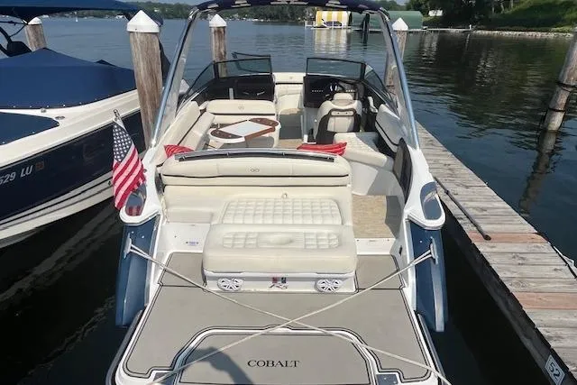 Slide: The Image of 2018 Cobalt R5 boat docked, featuring spacious seating and American flag. - 5