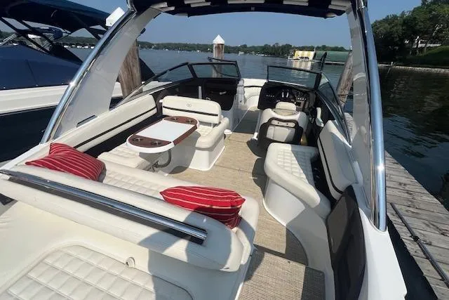 Slide: The Image of 2018 Cobalt R5 boat interior with white seating and red cushions on a sunny day. - 6