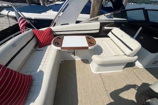 Slide: The Image of 2018 Cobalt R5 boat interior with white seating, red pillows, and a central table. - 8
