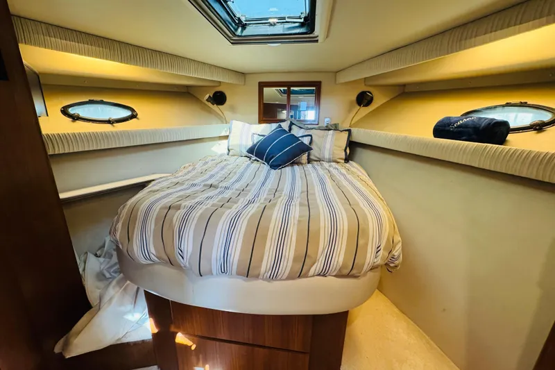 Slide: The Image of Cozy bedroom in 1991 Californian 55 Cockpit Motor Yacht with striped bedding and porthole windows. - 100