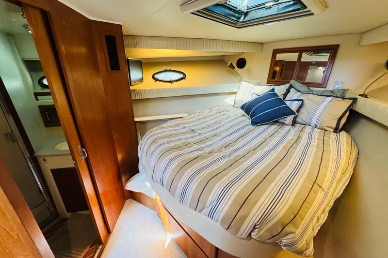 Slide: The Image of Cozy bedroom in 1991 Californian 55 Cockpit Motor Yacht with striped bedding and skylight. - 101
