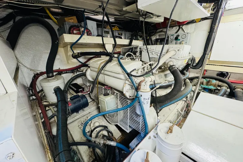 Slide: The Image of Engine room of 1991 Californian 55 Cockpit Motor Yacht with visible machinery and hoses. - 110