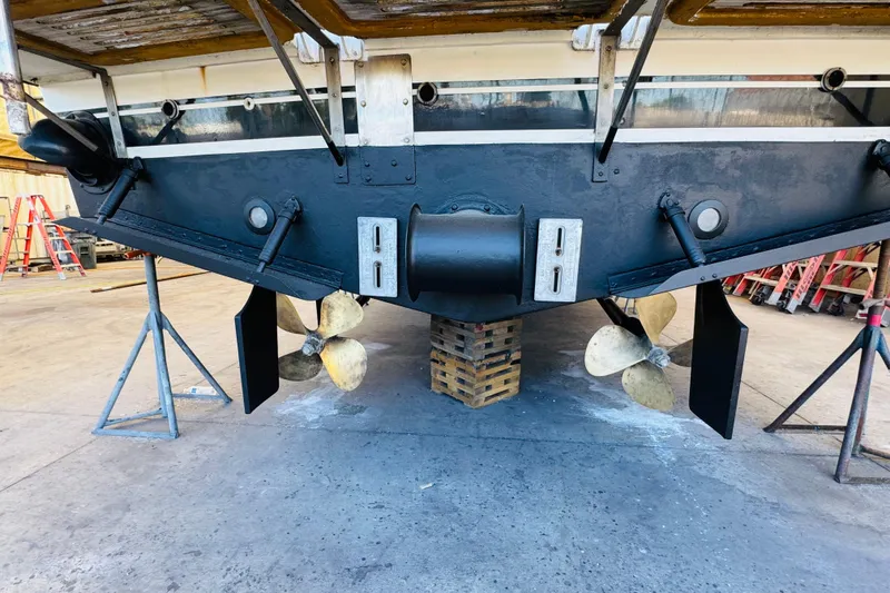 Slide: The Image of 1991 Californian 55 Cockpit Motor Yacht under maintenance, showing propellers and rudders. - 123