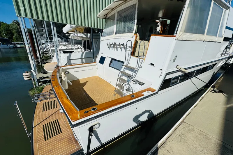 Slide: The Image of 1991 Californian 55 Cockpit Motor Yacht docked, showcasing spacious deck and elegant design. - 23