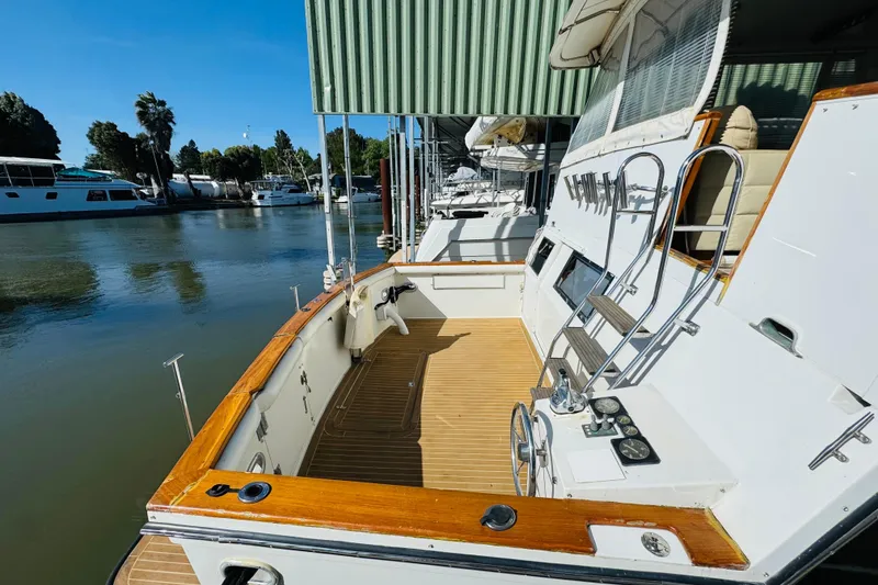 Slide: The Image of 1991 Californian 55 Cockpit Motor Yacht docked, showcasing spacious deck and elegant design. - 24
