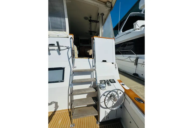Slide: The Image of 1991 Californian 55 Cockpit Motor Yacht with ladder and helm station in marina setting. - 27