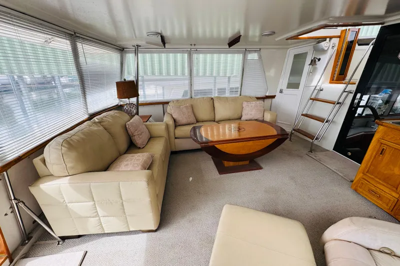 Slide: The Image of Luxurious interior of 1991 Californian 55 Cockpit Motor Yacht with beige sofas and wooden table. - 34