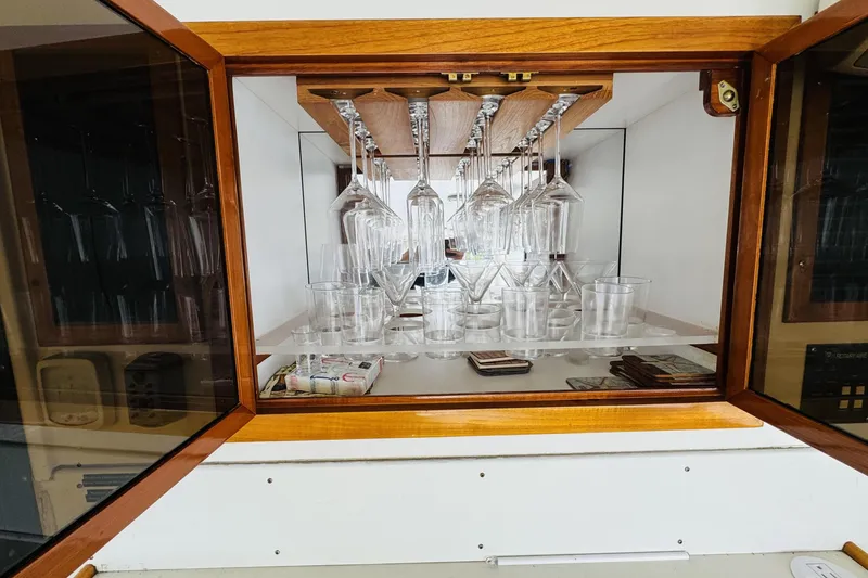 Slide: The Image of Glassware cabinet on 1991 Californian 55 Cockpit Motor Yacht, featuring wine and cocktail glasses. - 37