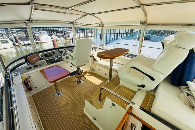 Slide: The Image of 1991 Californian 55 Cockpit Motor Yacht interior with helm, seating, and wooden accents. - 4