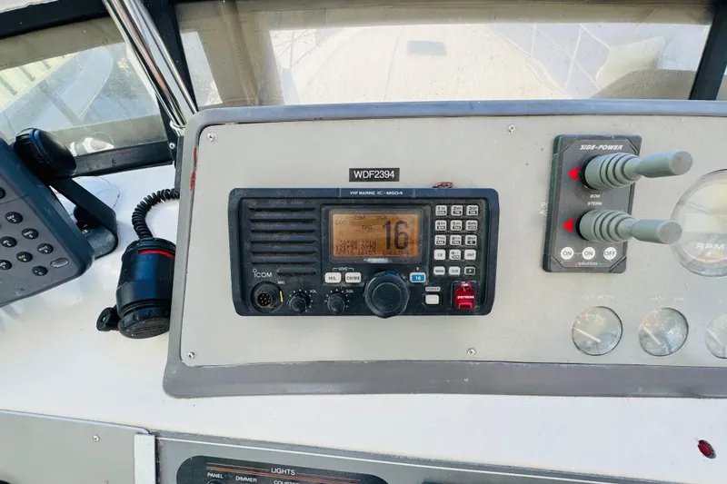 Slide: The Image of Control panel of a 1991 Californian 55 Cockpit Motor Yacht with radio and throttle controls. - 61