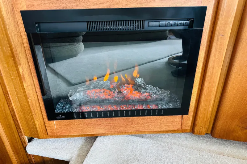 Slide: The Image of Electric fireplace in 1991 Californian 55 Cockpit Motor Yacht interior, featuring realistic glowing logs. - 76