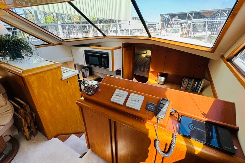 Slide: The Image of Interior of 1991 Californian 55 Cockpit Motor Yacht with helm, microwave, and cozy cabin. - 77