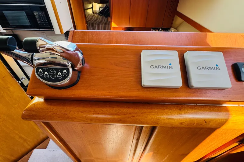 Slide: The Image of 1991 Californian 55 Cockpit Motor Yacht helm with Garmin controls and throttle levers. - 79