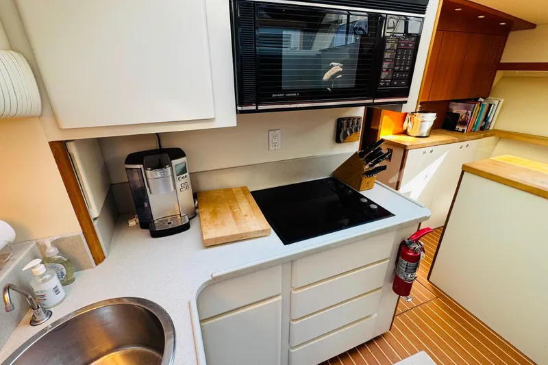 Slide: The Image of Modern kitchen in a 1991 Californian 55 Cockpit Motor Yacht with appliances and wooden accents. - 86