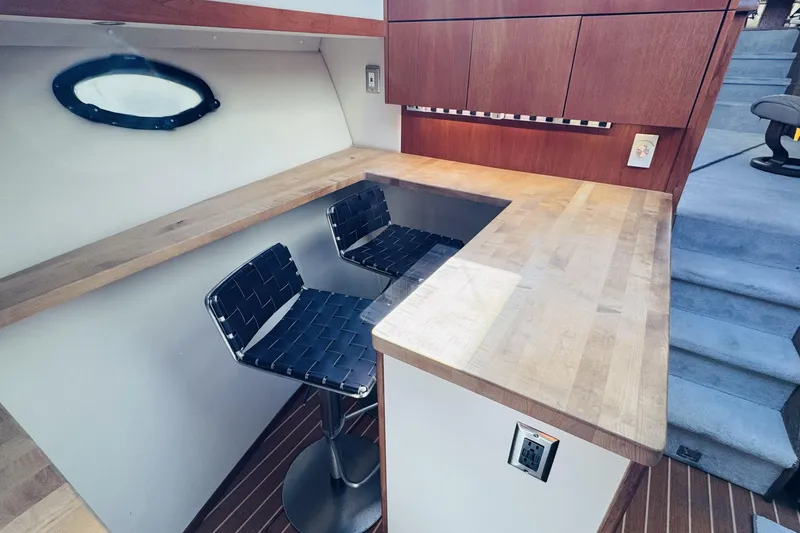 Slide: The Image of Interior of 1991 Californian 55 Cockpit Motor Yacht with wooden countertops and bar stools. - 88