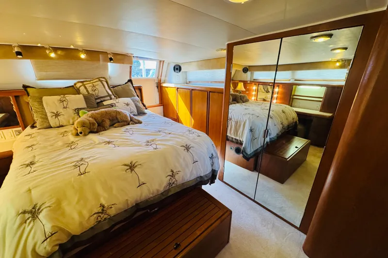 Slide: The Image of Luxurious bedroom in 1991 Californian 55 Cockpit Motor Yacht with plush bedding and mirrored closet. - 93