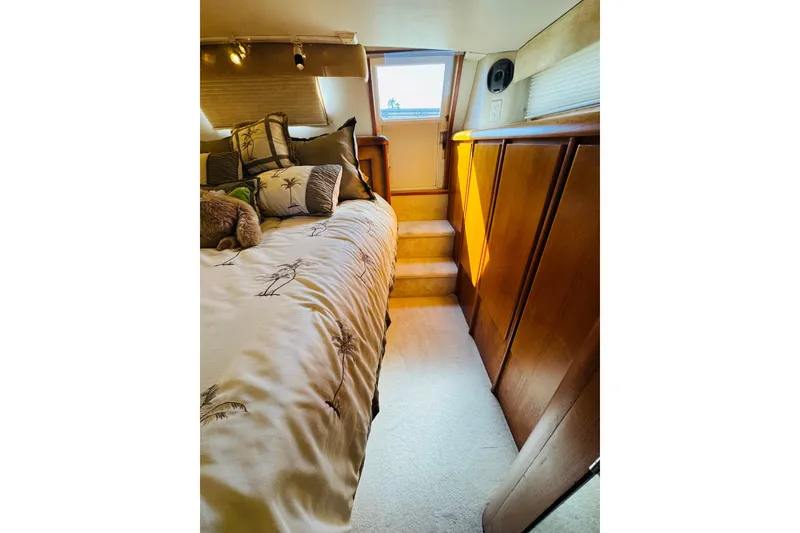 Slide: The Image of Luxurious bedroom interior of 1991 Californian 55 Cockpit Motor Yacht with elegant bedding and wooden cabinetry. - 94