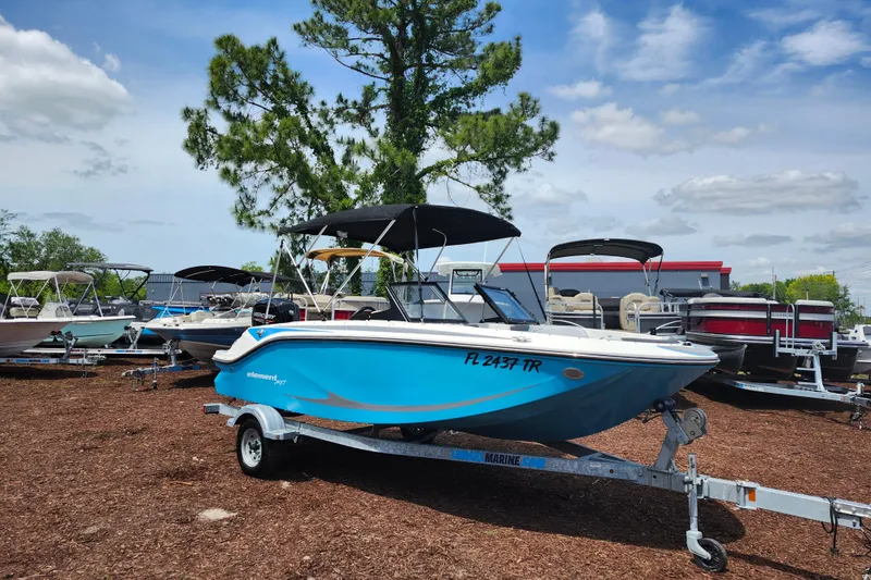 The Image of 2023 Bayliner Element M17 boat on trailer, displayed outdoors under a clear sky. - 1