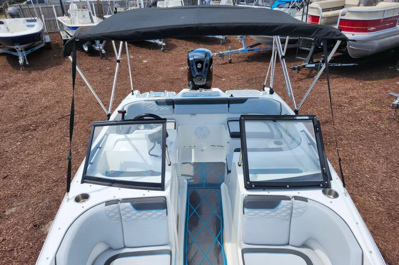Slide: The Image of 2023 Bayliner Element M17 boat interior with seating and windshield, parked outdoors. - 12