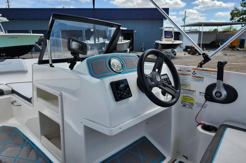 Slide: The Image of 2023 Bayliner Element M17 boat dashboard with steering wheel and controls. - 18