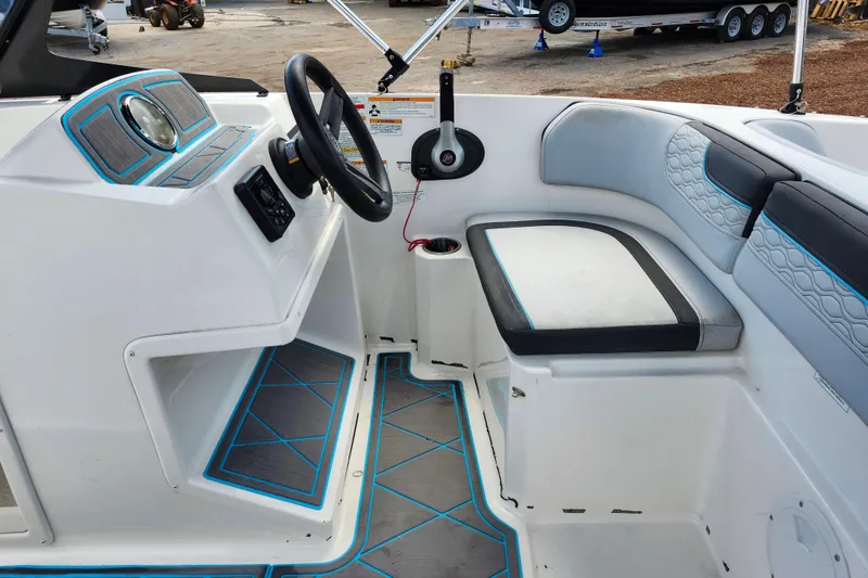 Slide: The Image of 2023 Bayliner Element M17 boat interior with steering wheel and seating area. - 22