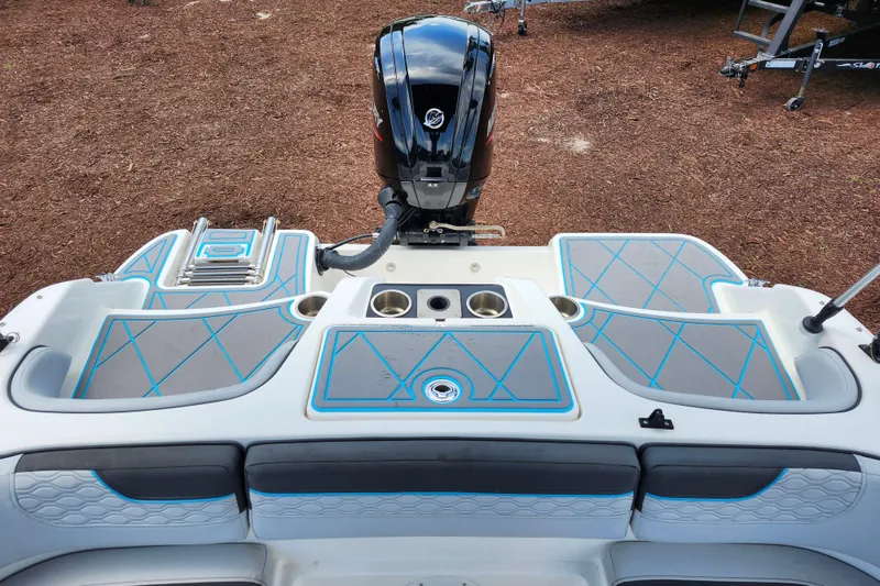 Slide: The Image of 2023 Bayliner Element M17 boat deck with motor, featuring blue-accented seating and cup holders. - 23