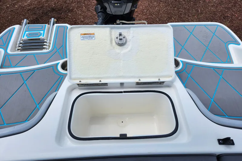 Slide: The Image of 2023 Bayliner Element M17 boat storage compartment with open lid and swim platform. - 24