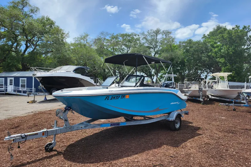 Slide: The Image of 2023 Bayliner Element M17 boat on trailer, parked outdoors with trees in background. - 3