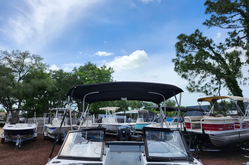 Slide: The Image of 2023 Bayliner Element M17 boat displayed outdoors with other boats under a clear sky. - 9